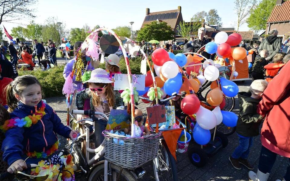 Staphorst begint Koningsdag met een optocht met versierde fietsen.