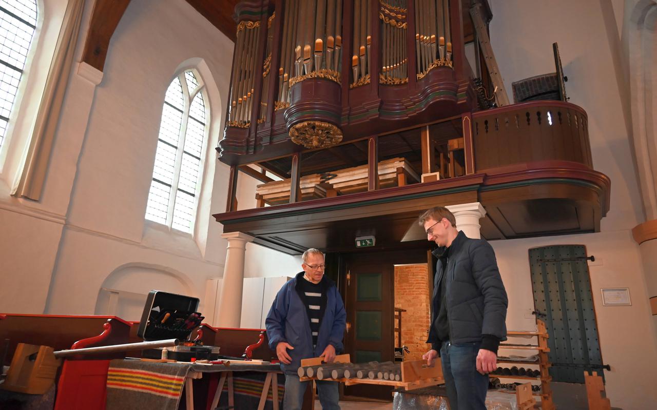 Roelof Kuijer (links) en Han van der Horst sjouwen met een krat met orgelpijpen. Elk van de 654 pijpen krijgt een beurt.