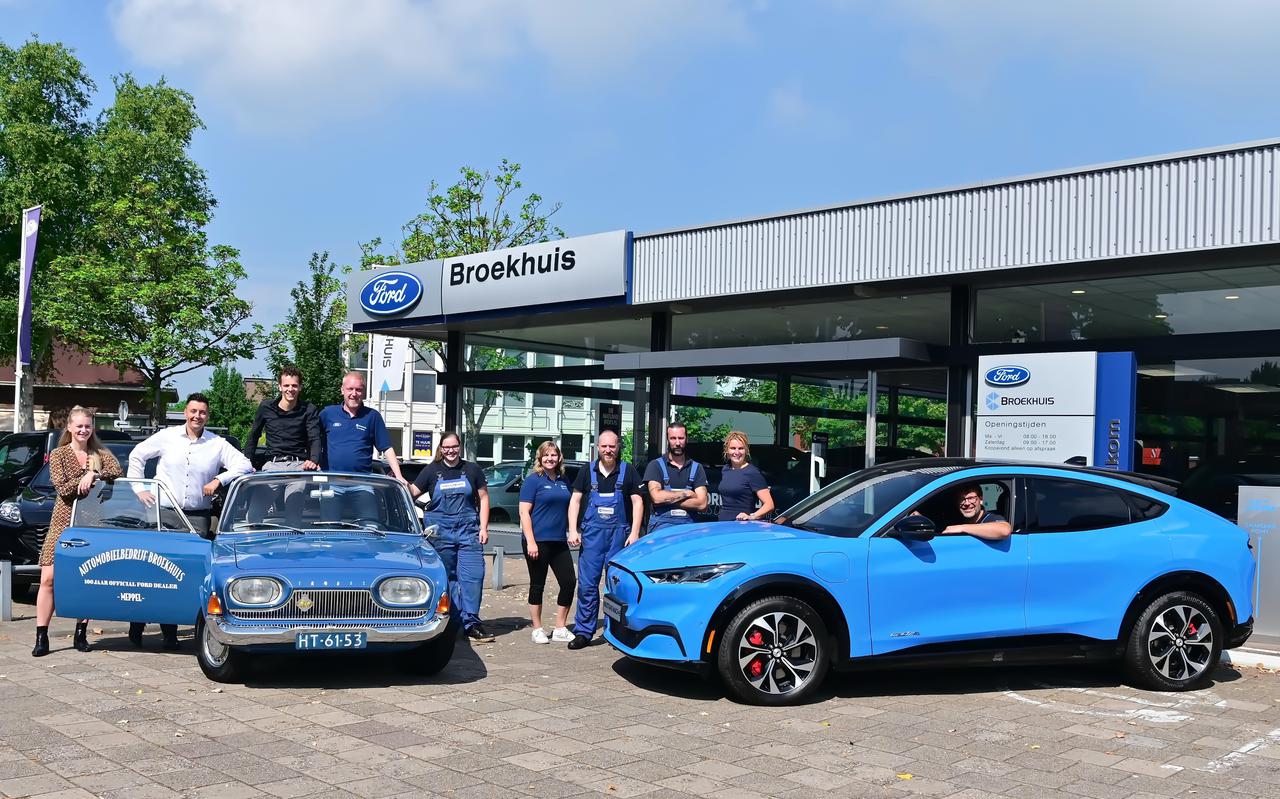 Het team van Broekhuis Meppel bij de oude Ford Taunus en een nieuwe Mustang Mach-E. 