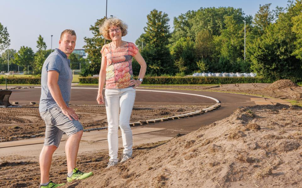 Milco Winters (bestuurslid technische zaken) en Petra Hasper (de nieuwe voorzitter) poseren samen bij het terrein waarop de gloednieuwe atletiekbaan van De Sprinter gaat verrijzen.