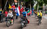 Honderden vrolijke fietsers rijden het vlakke Kerkplein op voor het fietsdefilé.