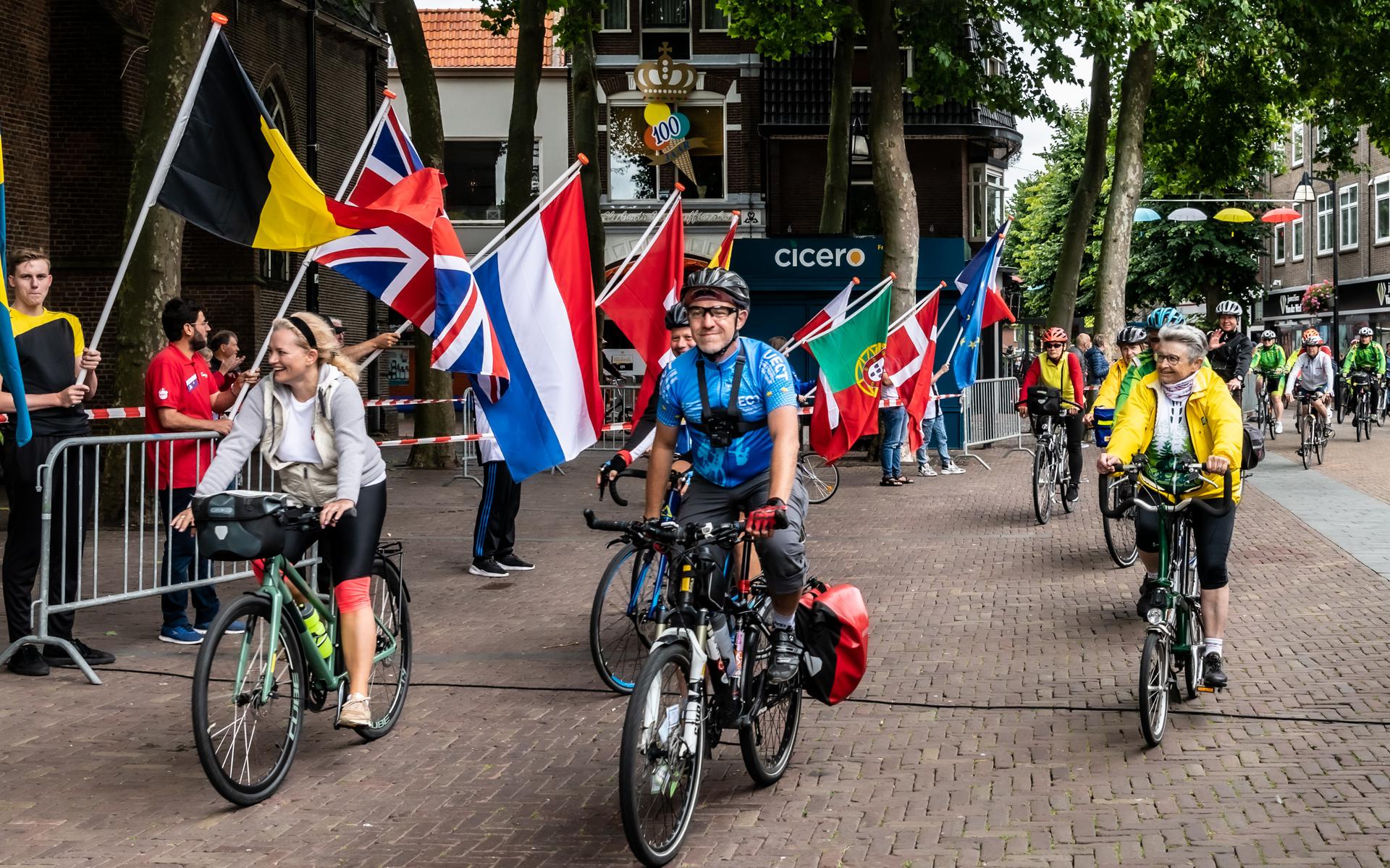 Honderden vrolijke fietsers rijden het vlakke Kerkplein op voor het fietsdefilé.