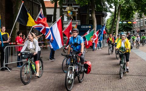 Honderden vrolijke fietsers rijden het vlakke Kerkplein op voor het fietsdefilé.
