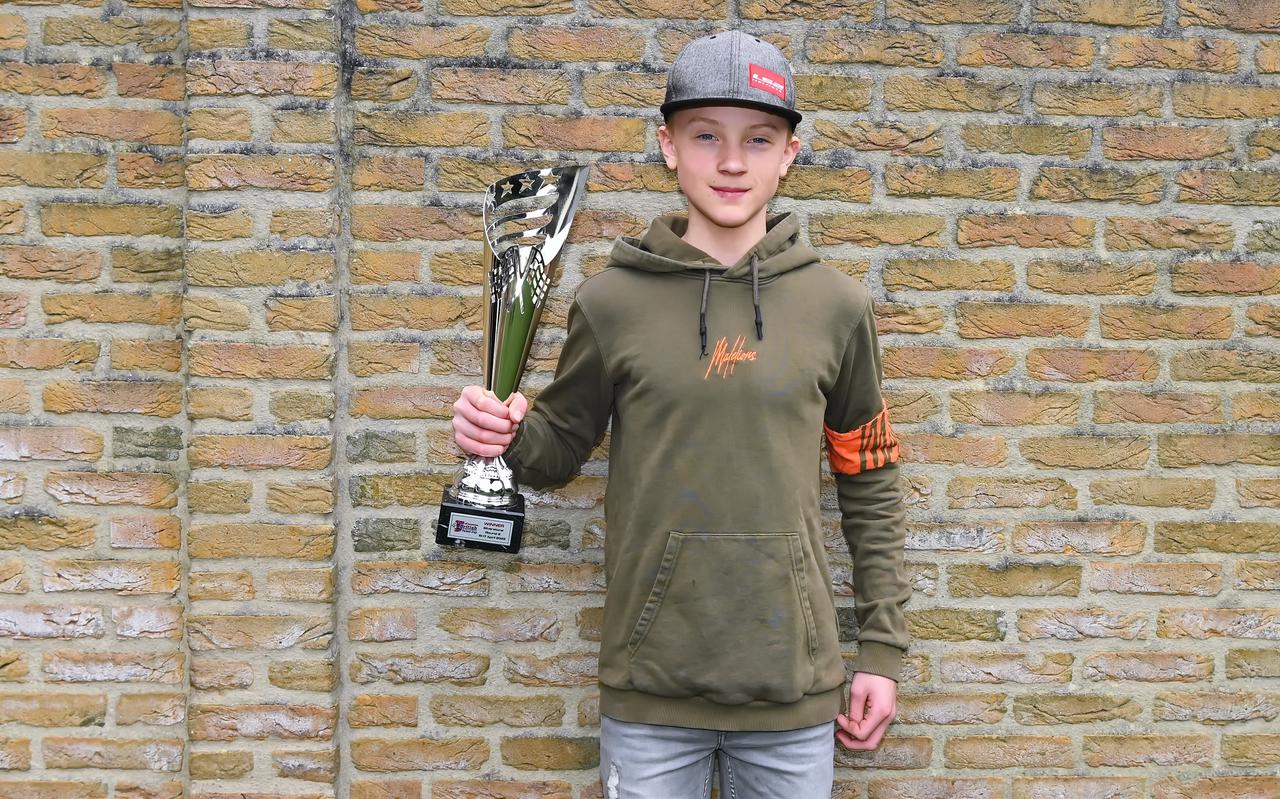 Een trotse Kiyano Veijer toont de beker die hij vorig jaar op het circuit van Silverstone bemachtigde. Hij won daar de tweede race om de British Talent Cup.