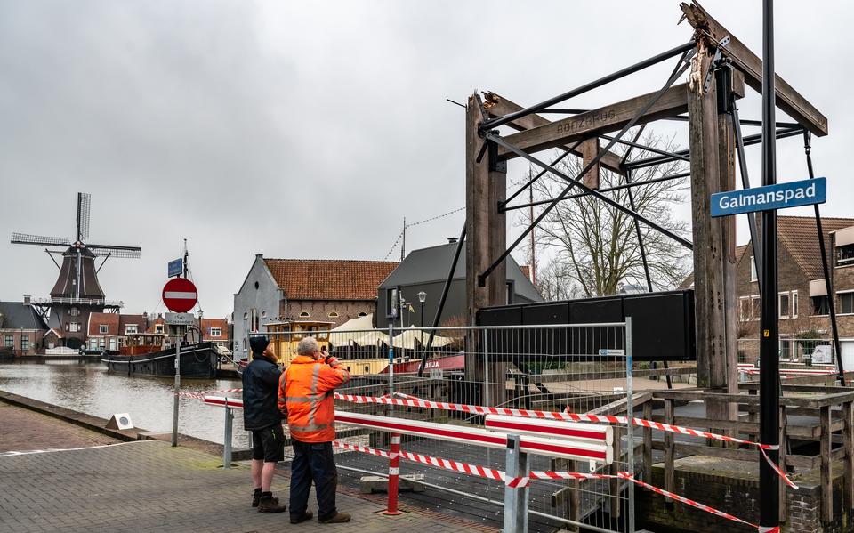 Twee mannen bekijken de gehavende brug.