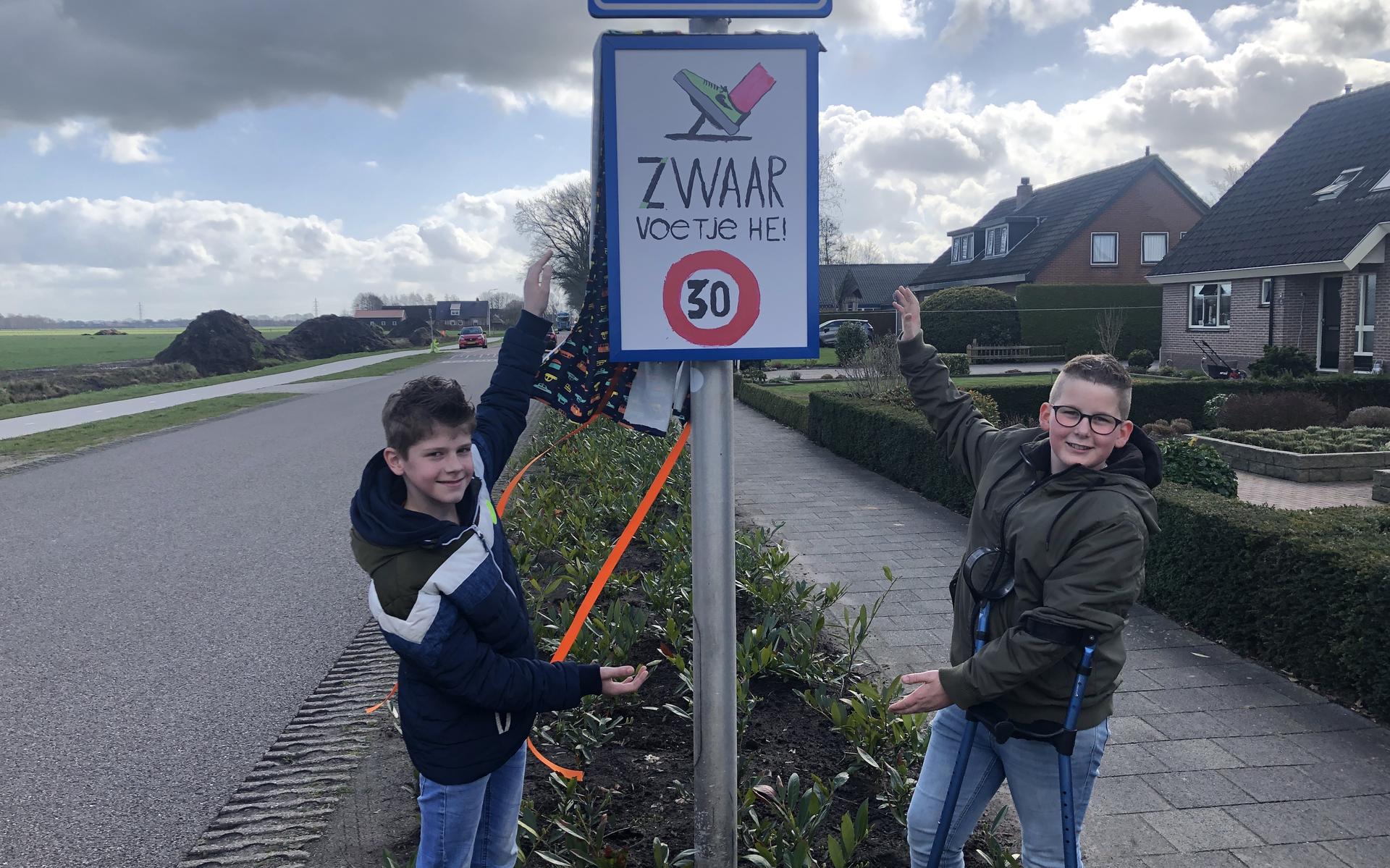 Leerlingen Dinand van Leusen en Danyl Seinen onthullen het bord die ze samen ontwierpen.