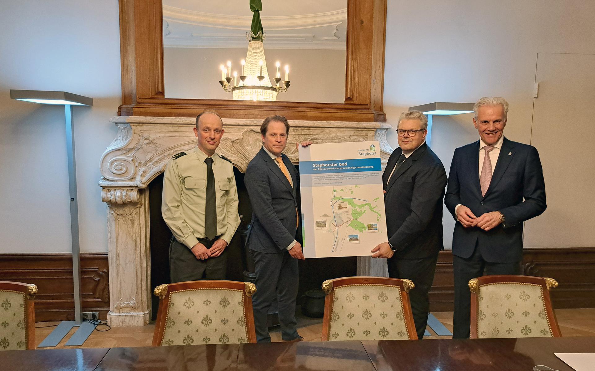 Burgemeester Jan ten Kate van Staphorst overhandigt het bod. Uiterst rechts: wethouder Lucas Mulder.