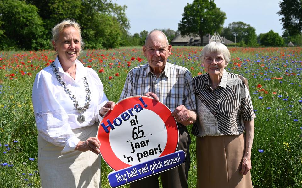 Anno en Femmie Venemann met burgemeester Inge Nieuwenhuizen bij wat in deze tijd van het jaar dagelijks hun uitzicht is: papavers en korenbloemen.
