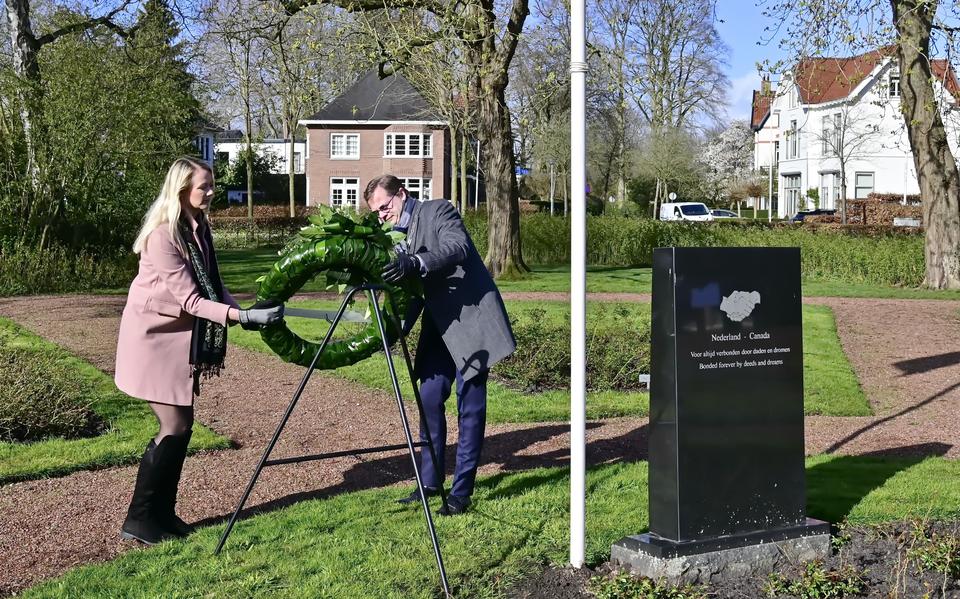 Burgemeester Richard Korteland en zijn partner leggen een krans bij het oorlogsmonument.