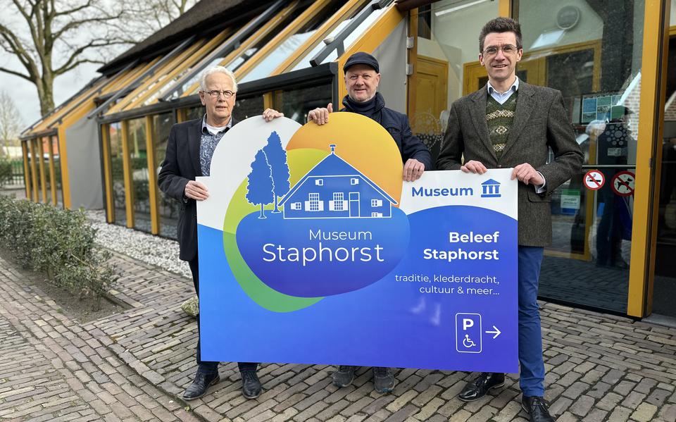 Bestuursleden Jan Talen, Gerrit Haasjes en Johan de Bruijn met het informatiebord van Museum Staphorst in de nieuwe huisstijl.