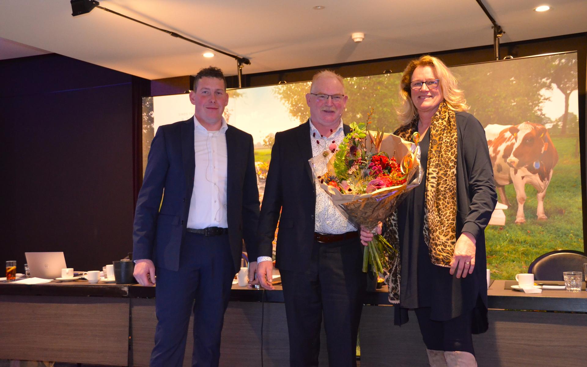 Nieuwe voorzitter Henk van Leusen overhandigt aan scheidend voorzitter Bart Kooiker en zijn vrouw Femmy een bos bloemen als blijk van waardering