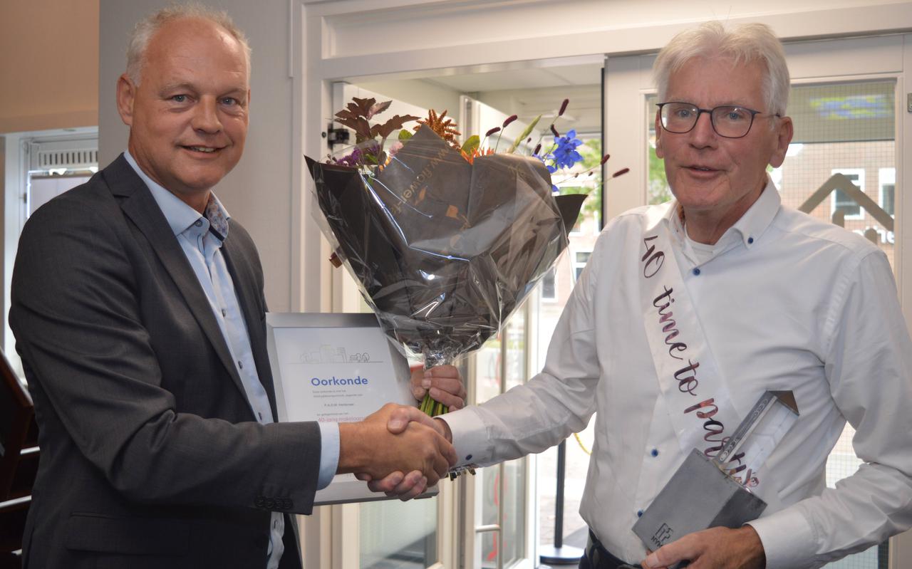Bloemen, een kunstwerk en een oorkonde voor jubilaris Pascal Hentenaar uit Zuidwolde, hem aangeboden door NVM Drenthe-voorzitter Gerben Zandbergen uit Meppel.