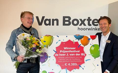 De heer Van der Bij neemt zijn prijs in ontvangst in de Van Boxtel hoorwinkel in Meppel.