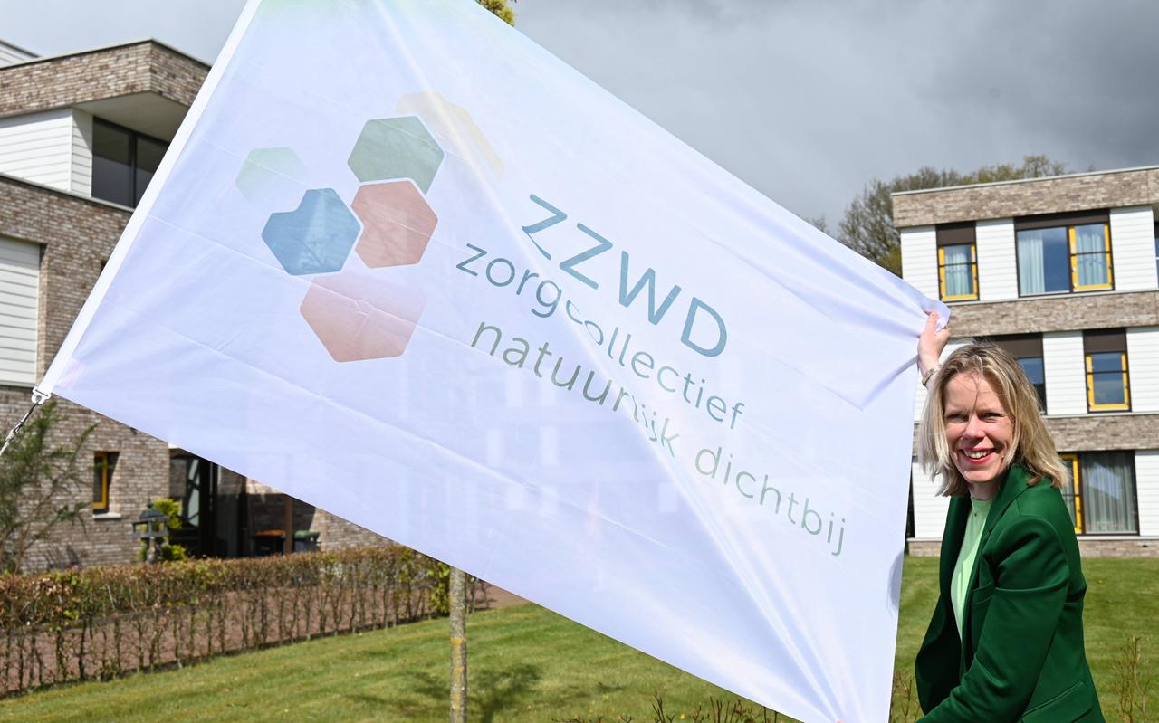 ZZWD-directeur Mariska Roeters showt de vlag met het nieuwe logo, alvorens deze in top gaat bij 't Neie Punt in Ruinen.