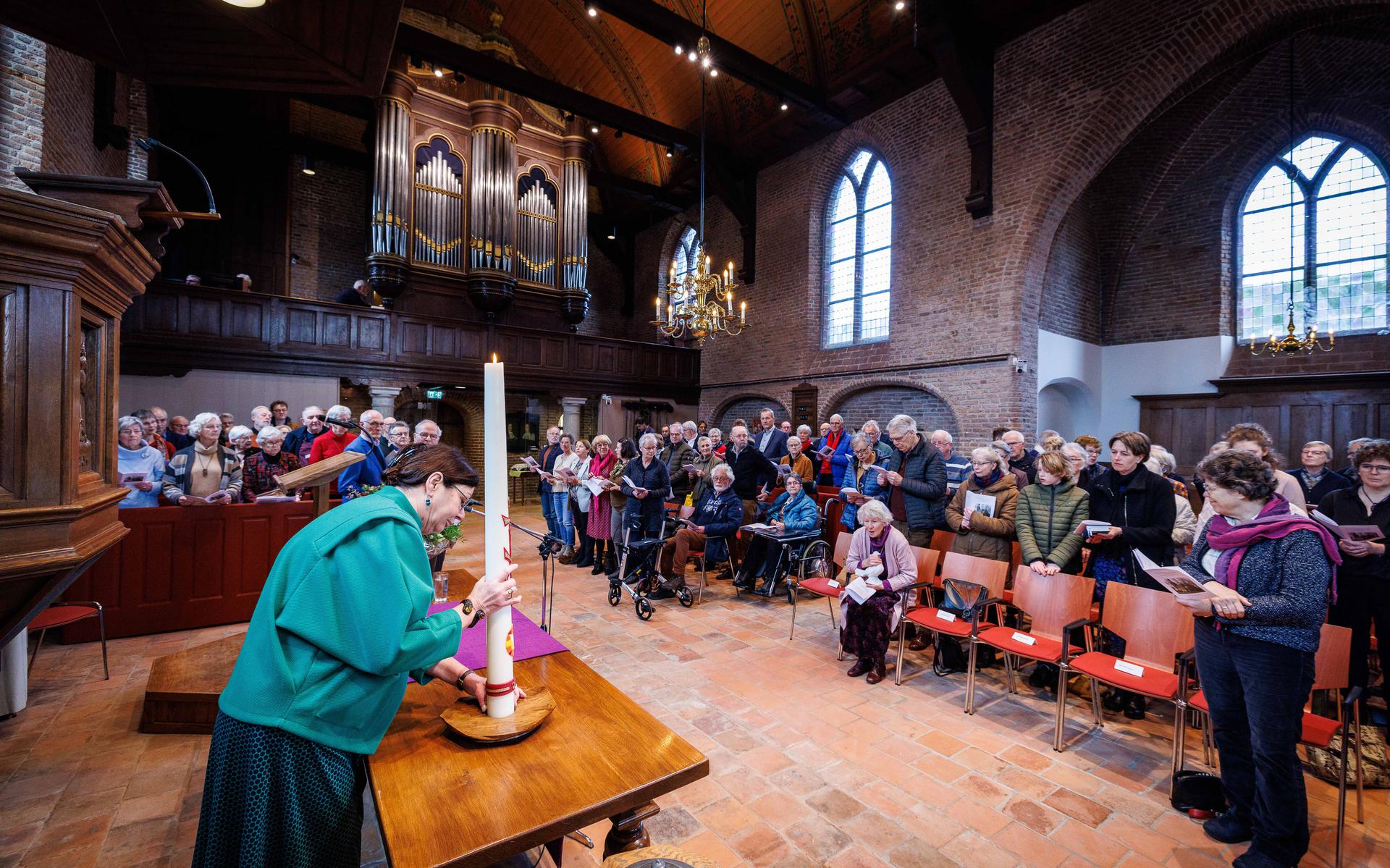 Tijdens de heropening van Nicolaaskerk in Dwingeloo. Bij het begin van de dienst werden de kaars, de bijbel binnen gebracht en het doopfont gevuld.