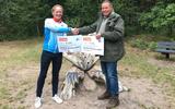 Namens Bos Bedden Loopgroep AG'85 overhandigt Albert Mussche twee cheques van 500 euro aan boswachter Nico Arkes. Het geld is bestemd voor de renovatie van het Belevingspad.