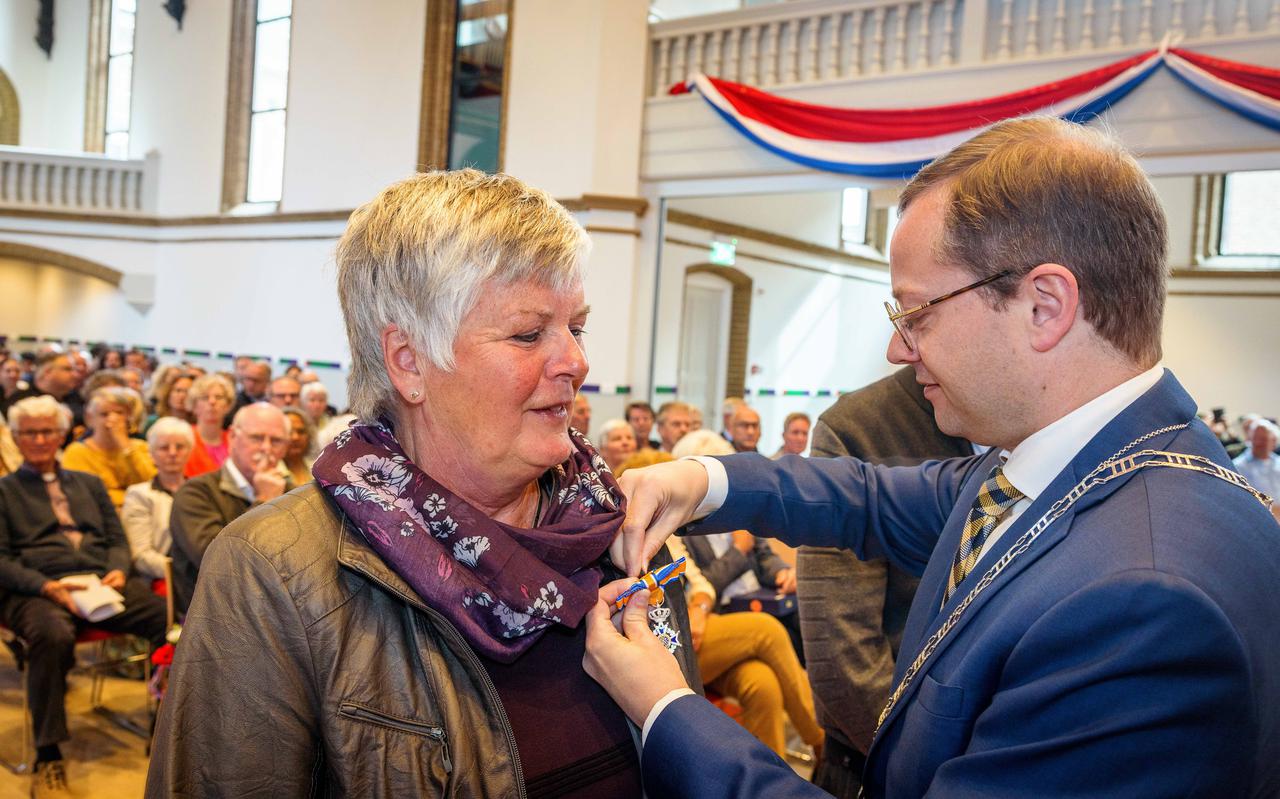 Burgemeester Korteland speldt een lintje op bij mevrouw Boer.